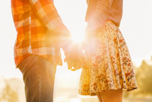 Young couple in love walking in the autumn park holding hands